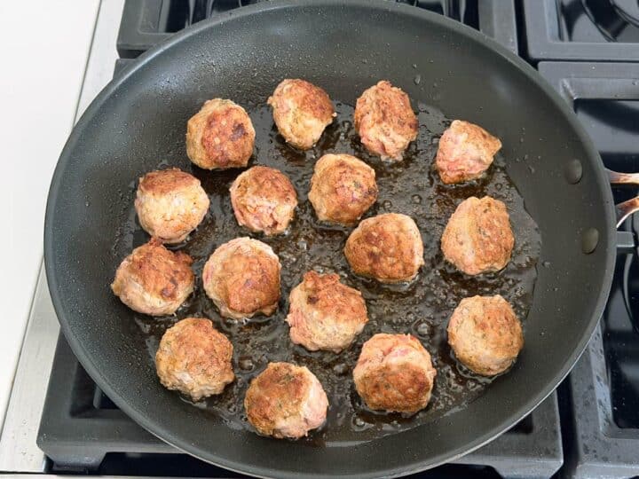 Browning the meatballs in the skillet.