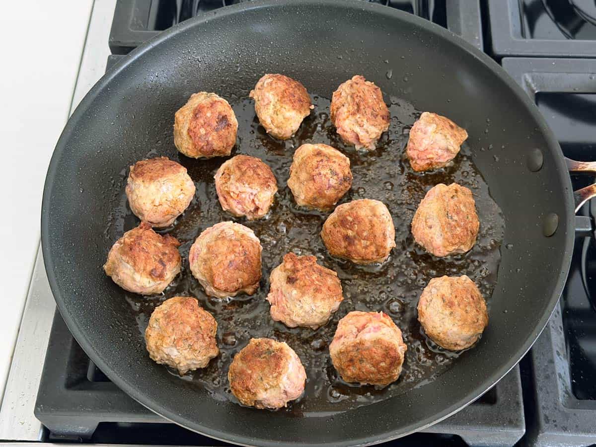 Browning the meatballs in the skillet.