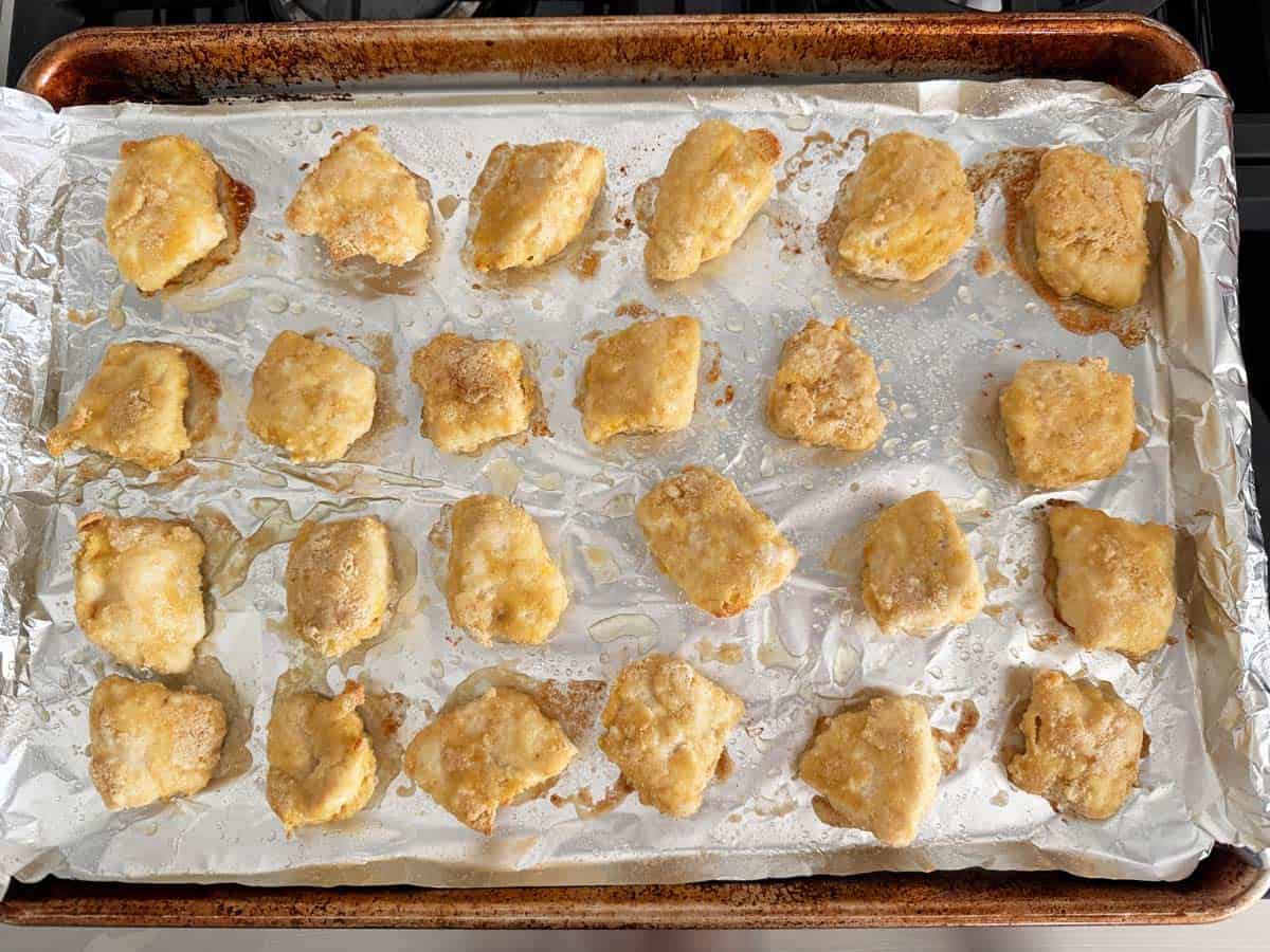 Keto chicken nuggets in a pan before broiling.