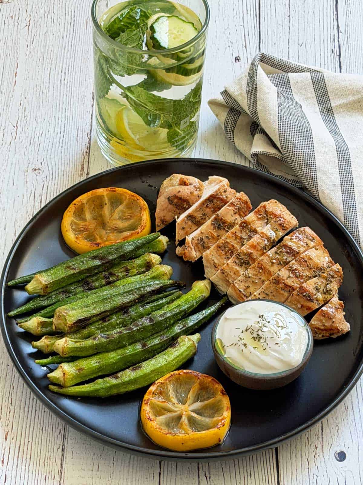 Cucumber water is served with Greek chicken and grilled okra.