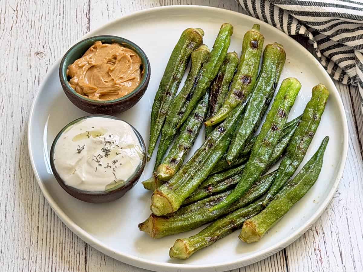 Grilled okra leftovers are served with two dipping sauces.