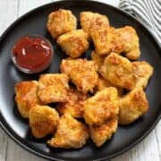 Keto chicken nuggets are served with ketchup for dipping.