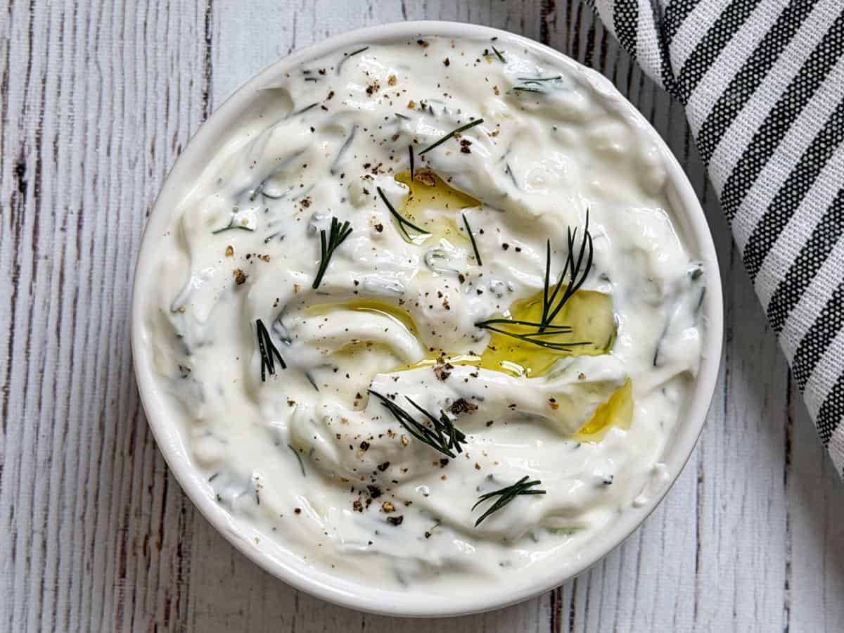 Tzatziki sauce is garnished with black pepper.