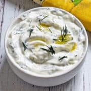 Tzatziki sauce is served in a white bowl.